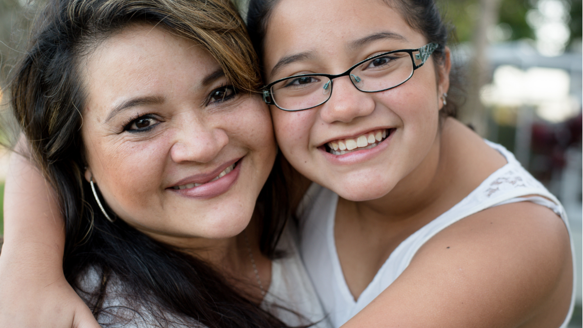 A woman and her daughter smile at the camera