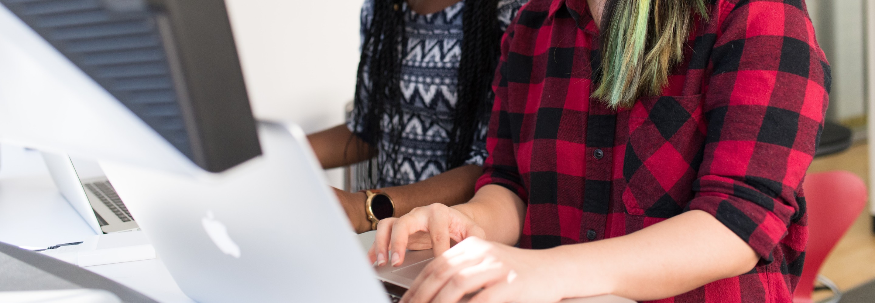 Two people typing at a computer together; Photo by Christina @ wocintechchat.com on Unsplash