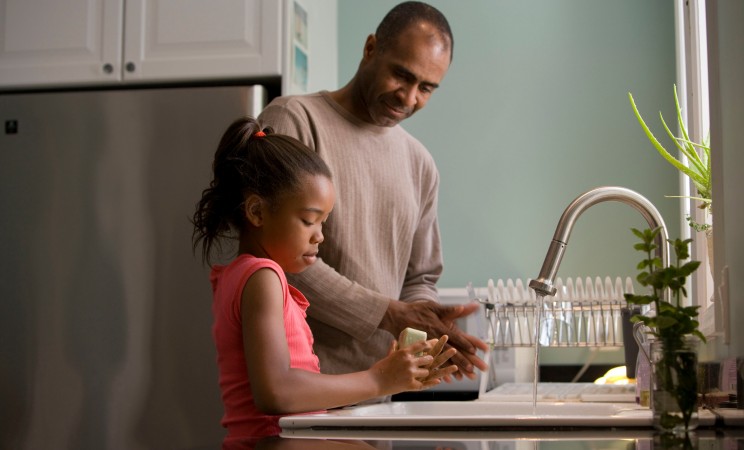 Father and daughter, cooking in the kitchen of their home.