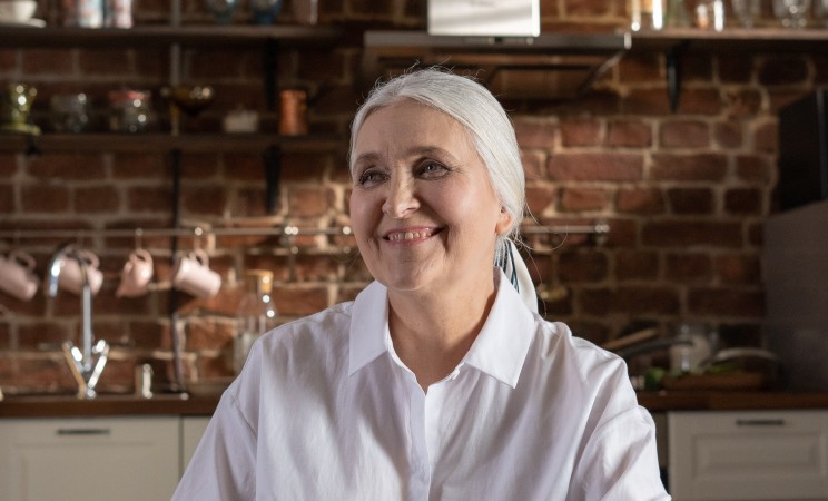 Photograph of a woman smiling at the kitchen table