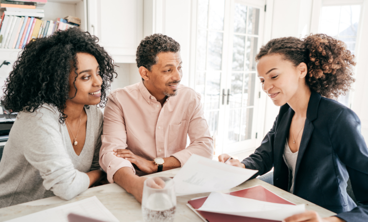 A man and a woman sit and meet with another woman who is a lawyer