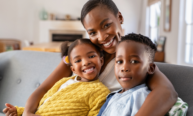 A woman holds her two children close