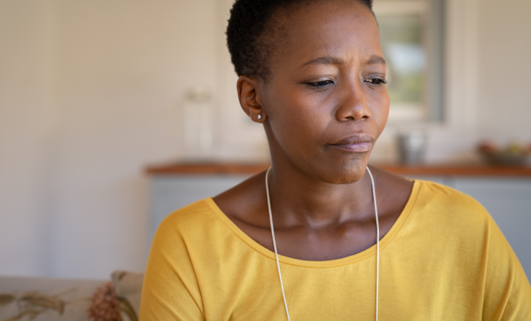 A woman in a yellow shirt frowns