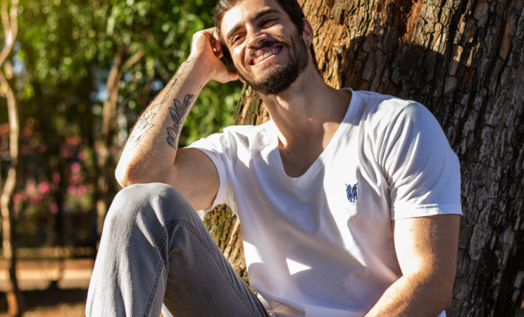 a man sits under a tree and smiles