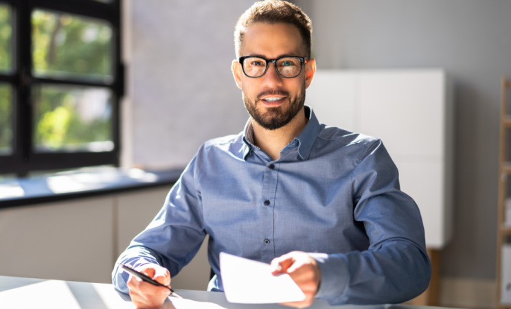 A man sits at his desk doing tax paperwork