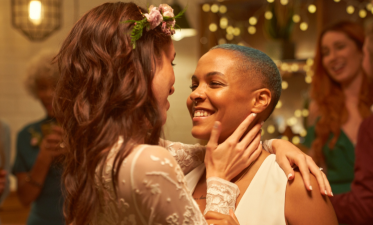 Two women slow dance at their wedding together