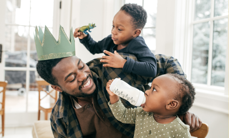 A father plays with his two toddlers.
