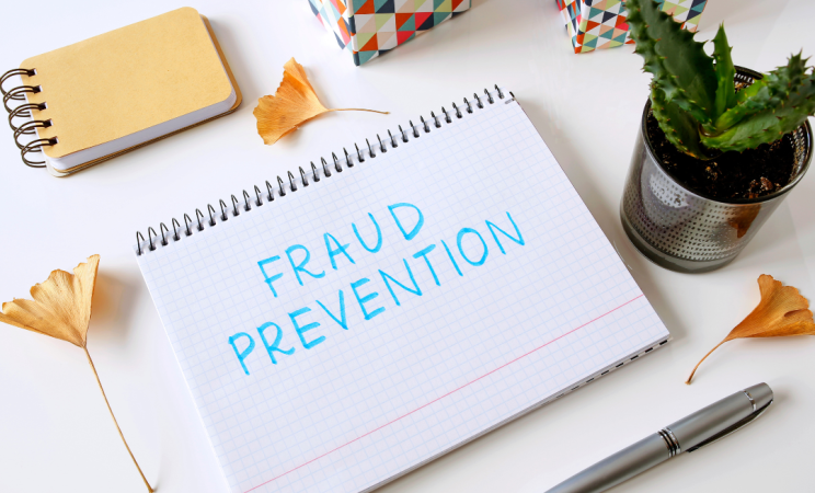 A notepad that says Fraud Prevention in blue marker