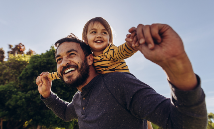 A father holds his child on his shoulders
