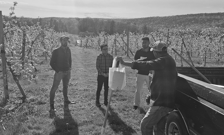 PFP staff in a farm field doing outreach