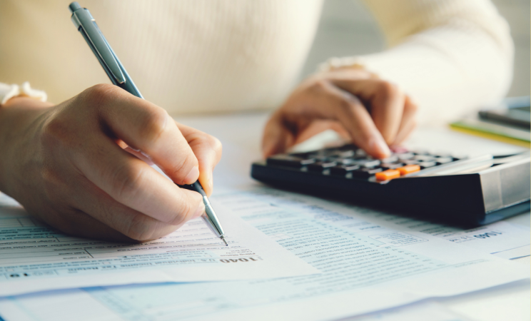 a woman uses a calculator to do her taxes