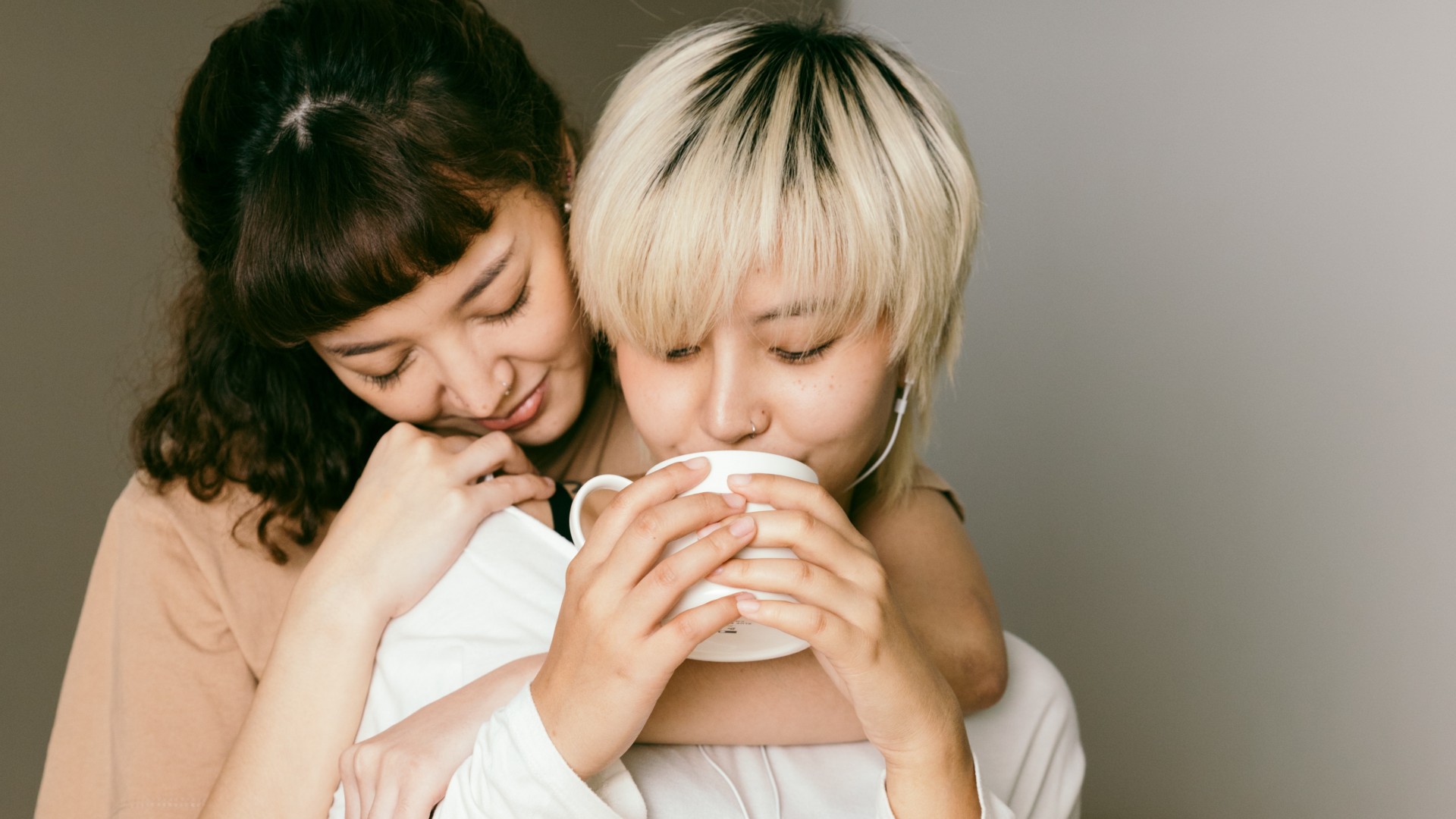 Women hugging while drinking coffee; Photo by Ketut Subiyanto on Pexels