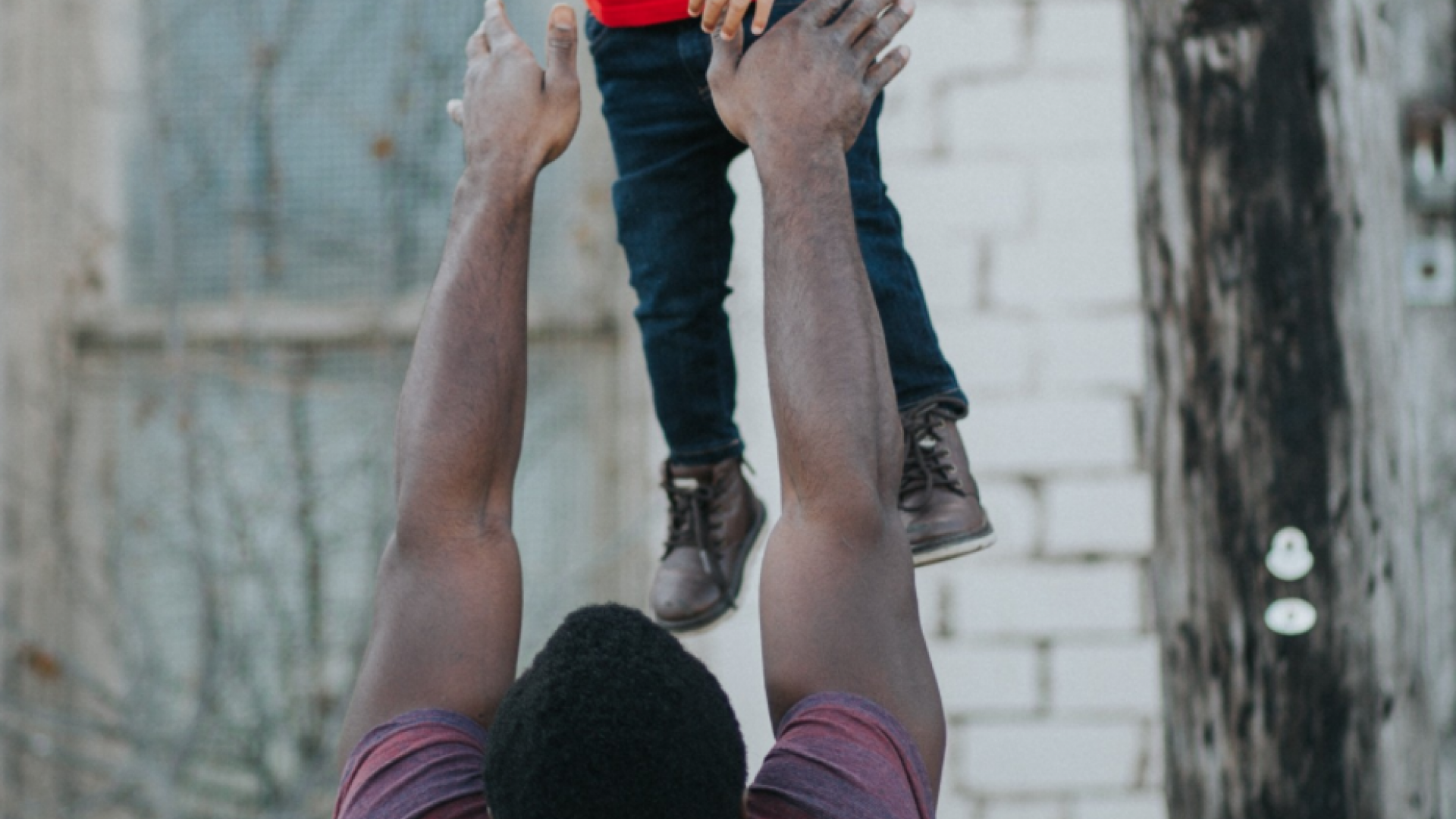 father lifting son in the air