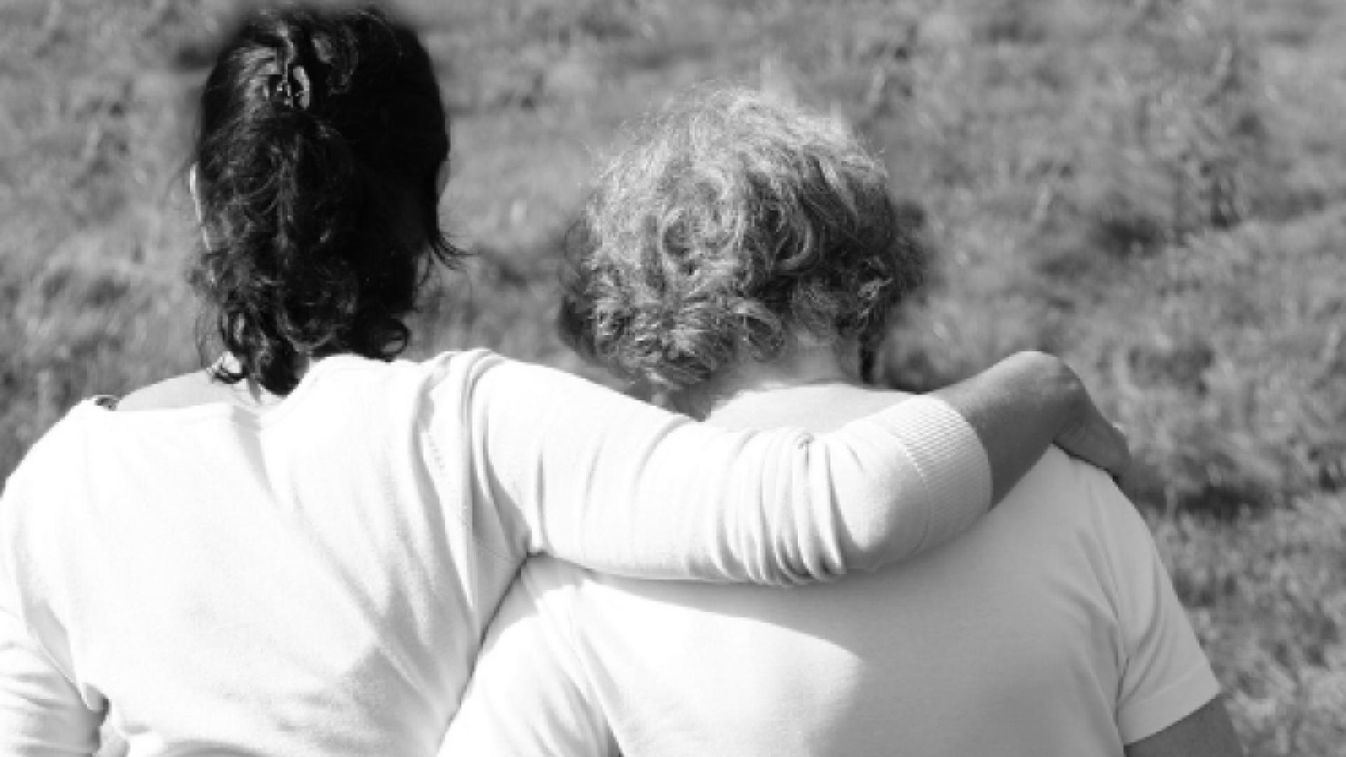 A mother and daughter with their arms over each other's shoulders