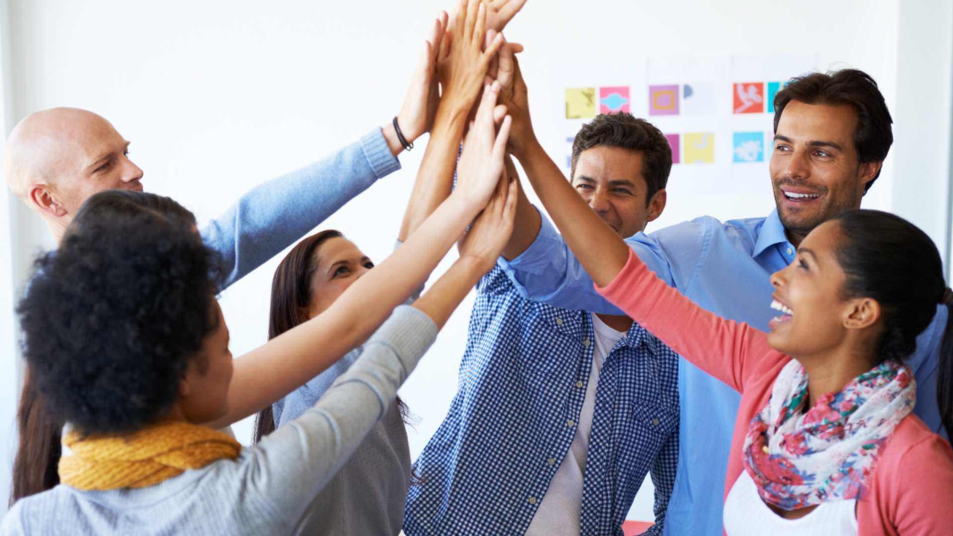 Six young people high five each other in celebration