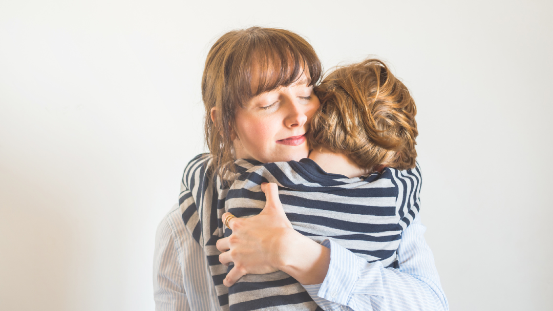 A mother hugs her child closely 