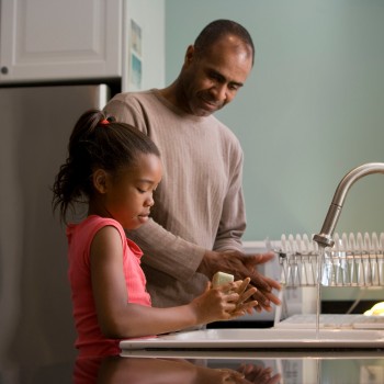 Father and daughter, cooking in the kitchen of their home.