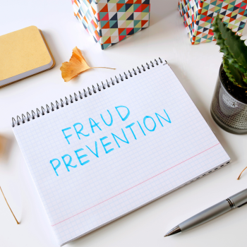 A notepad that says Fraud Prevention in blue marker